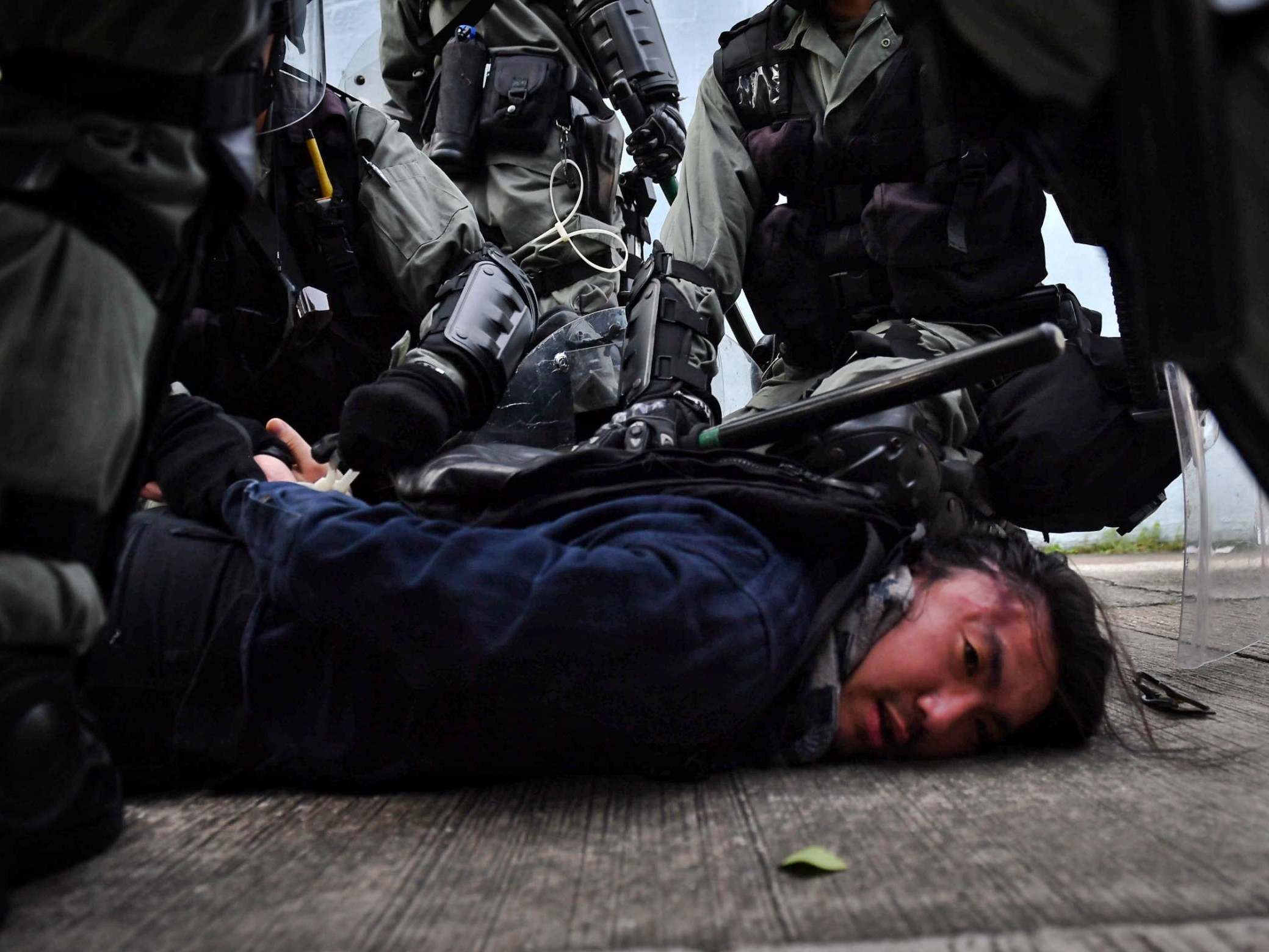 Riot police detain a protester at Kowloon Bay in Hong Kong