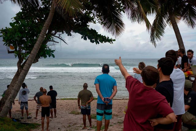 People gather on the Puerto Rico coast hours before the storm hits