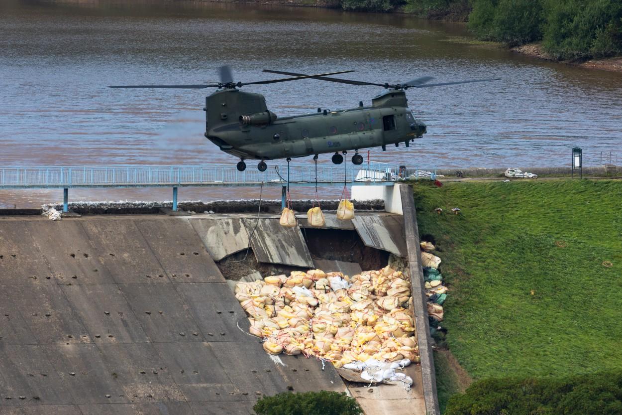 An RAF Chinook helicopter flies in sandbags to help repair the dam at Toddbrook Reservoir near Whaley Bridge