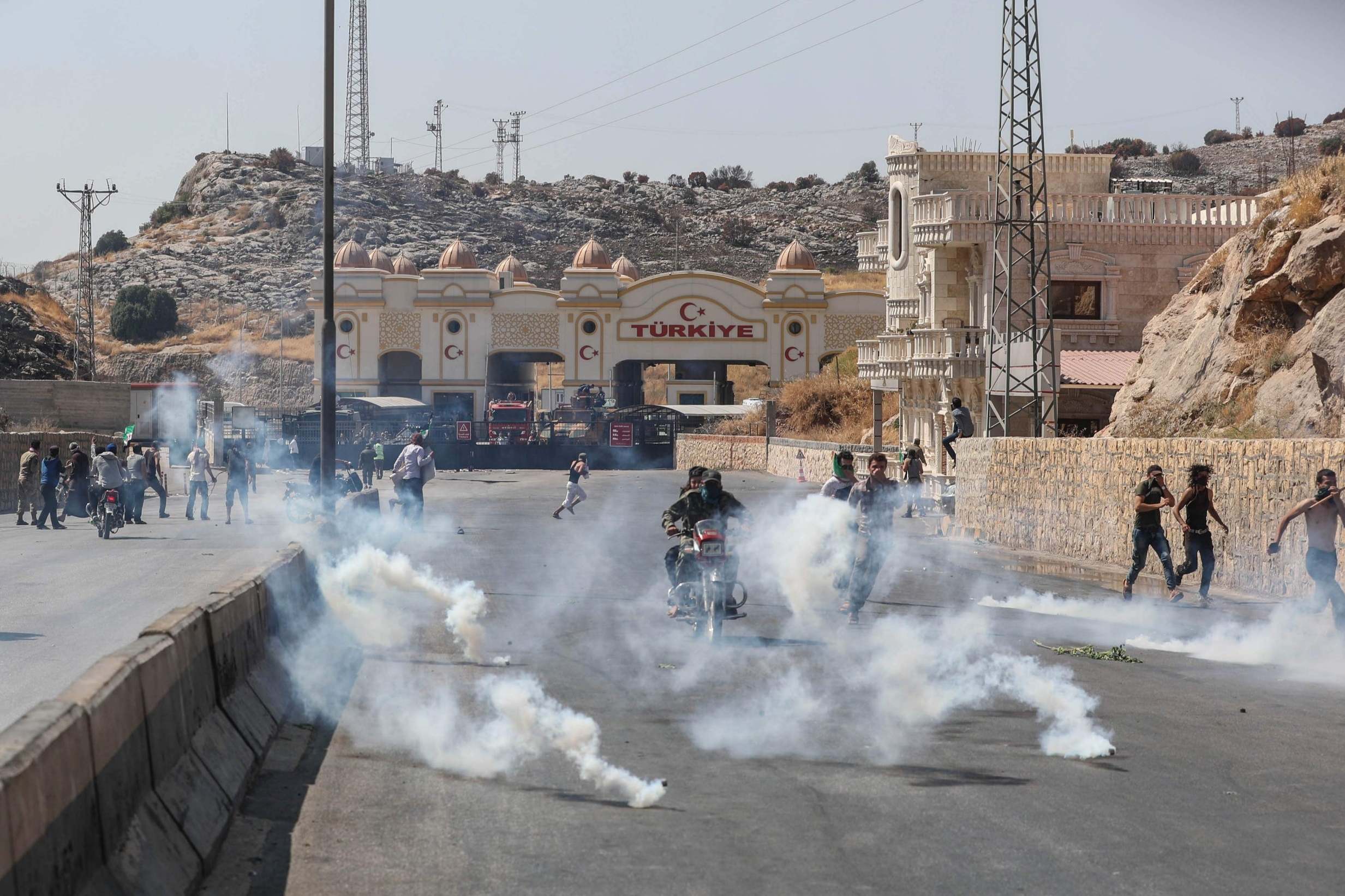 Turkish border guards fire tear gas canisters to disperse a crowd at the Bab al-Hawa crossing (AFP/Getty)