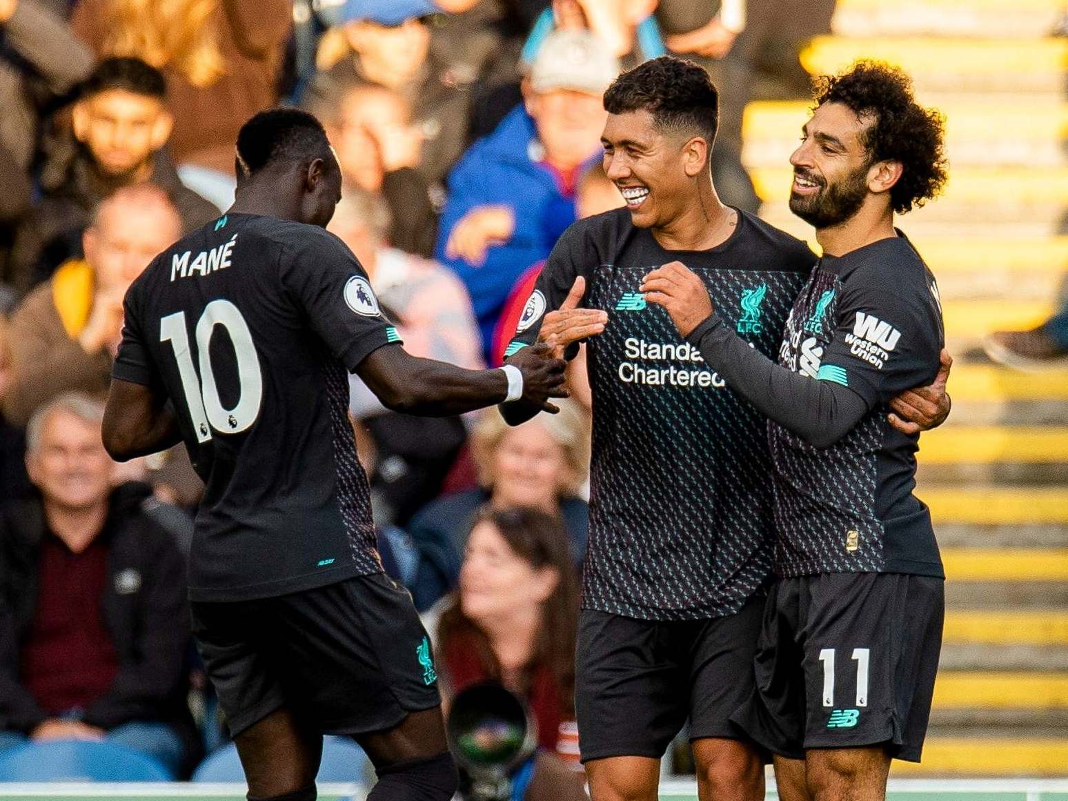 Firmino, centre, celebrates with Mane, left, and Salah