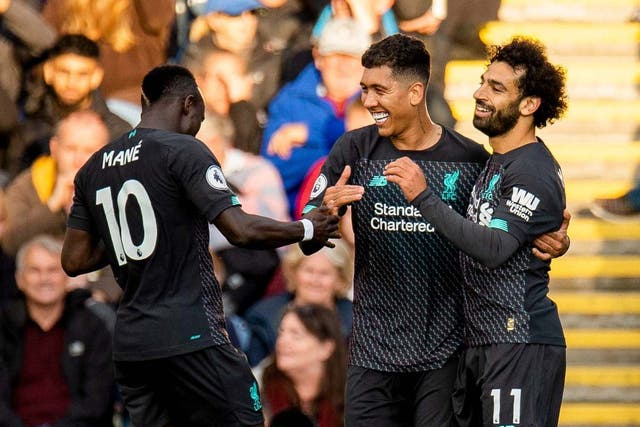 Firmino, centre, celebrates with Mane, left, and Salah