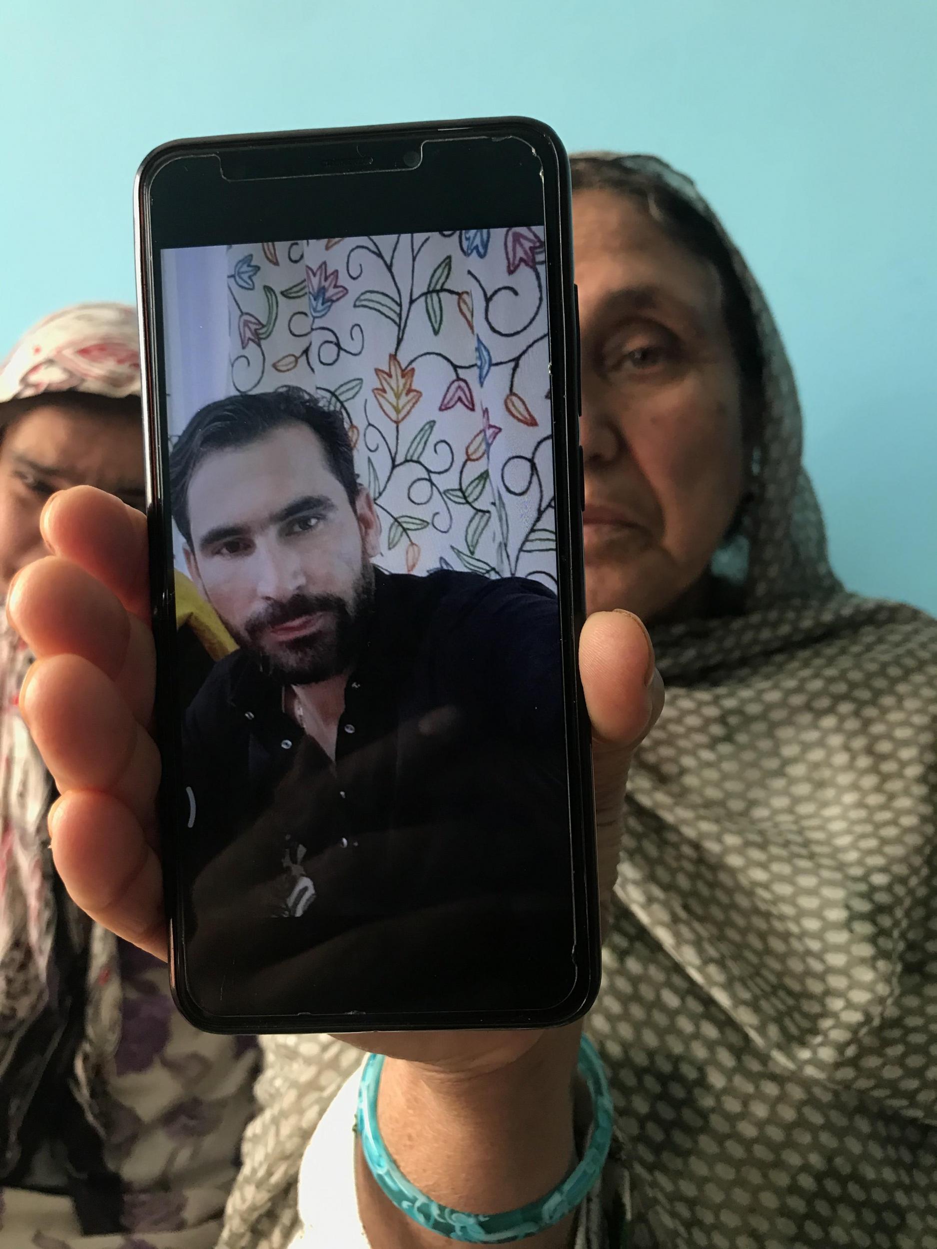 Raja Begum displays a picture of her son Amir Khan, detained since the night the Article 370 announcement was made