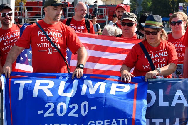 Supporters of US President Donald Trump hold banners as they attend commemorations marking 80 years since the outbreak of World War II on September 1, 2019 at Pilsudski Square in Warsaw, Poland
