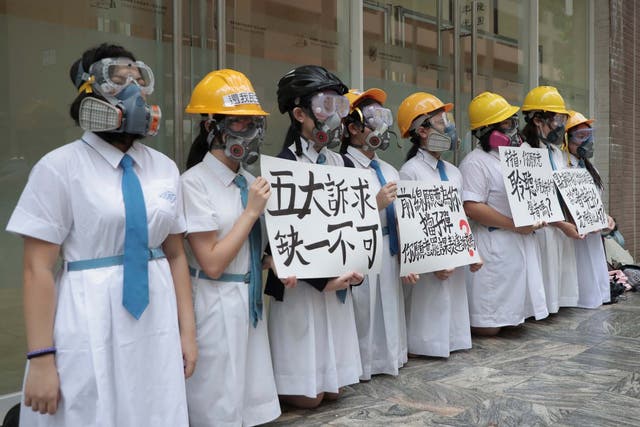 Students wearing gas masks and helmets at St Francis' Canossian College in Hong Kong