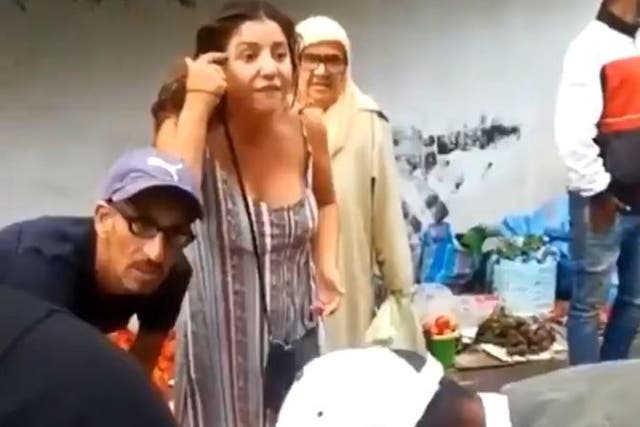 An unidentified British woman acosts Moroccan traders about keeping chickens