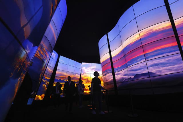 Visitors look at the LG Oled Screen installation at the 2018 IFA consumer electronics and home appliances trade fair during the fair's press day on August 30, 2018 in Berlin, Germany