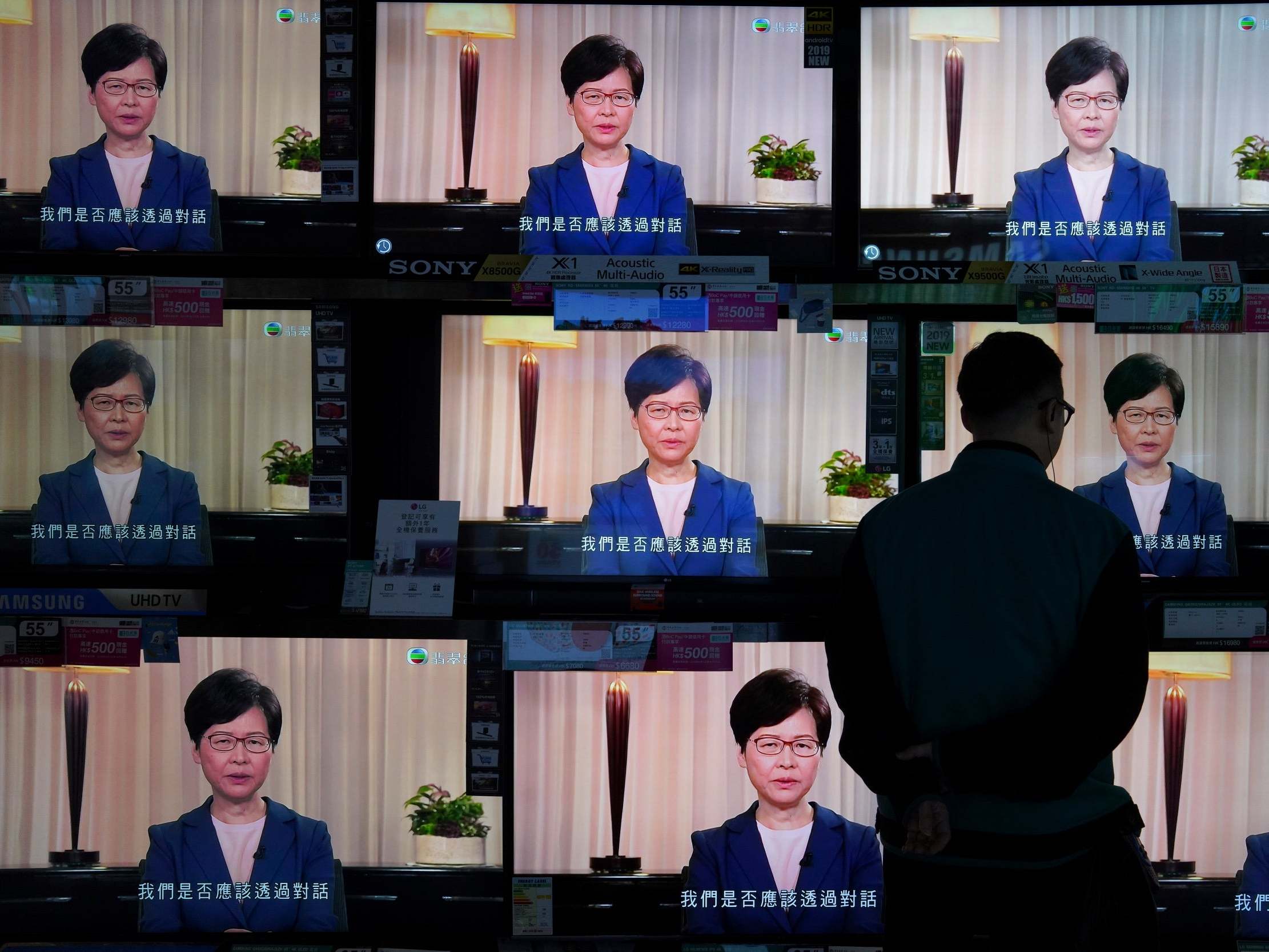 At an electrics retailer in the city, a man watches the chief executive’s announcement