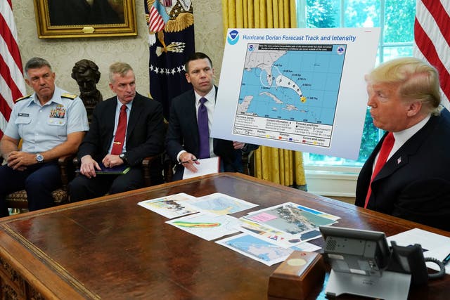 Donald Trump addresses reporters while holding doctored map