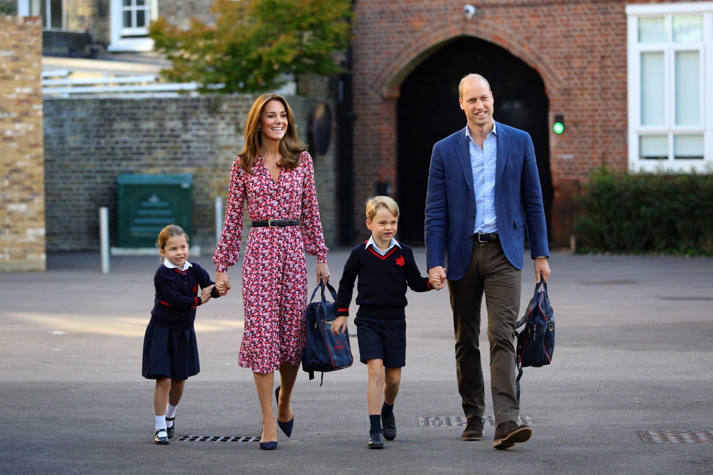 Princess Charlotte grips her mother's hand as she arrives for her first day at school with her family