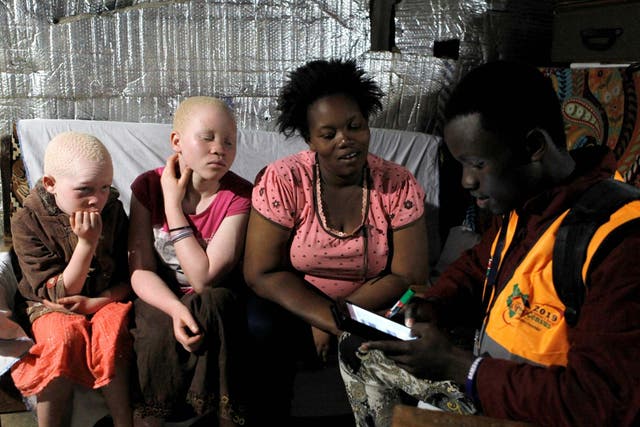 Recognition: an enumerator uses a census laptop to record details of a woman and her children with albinism in the 2019 Kenya Population and Housing Census in Nairobi