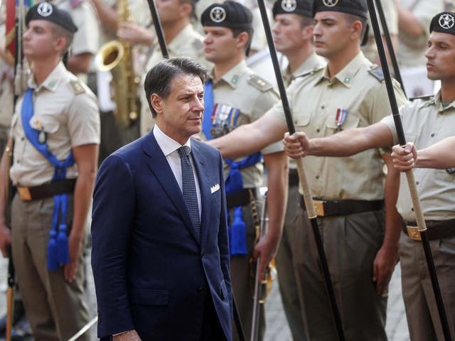 Giuseppe Conte, Italy's prime minister, walks past Italian Armed Forces members as he arrives at Chigi Palace to open the meeting of the cabinet in Rome