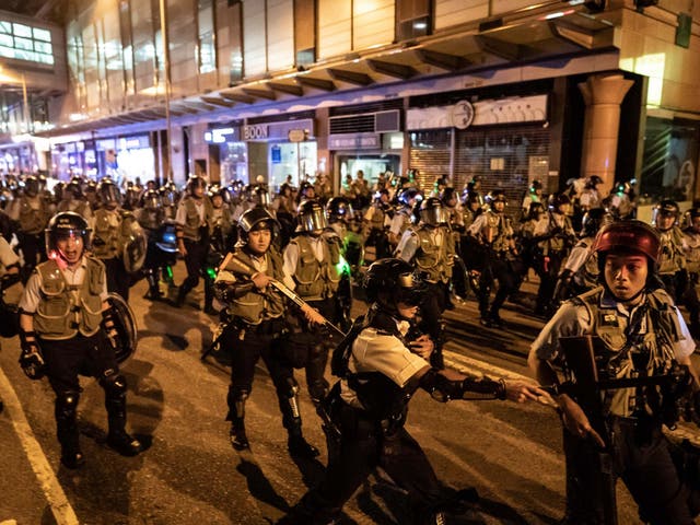 Police officers charge to disperse protesters outside Po Lam Station