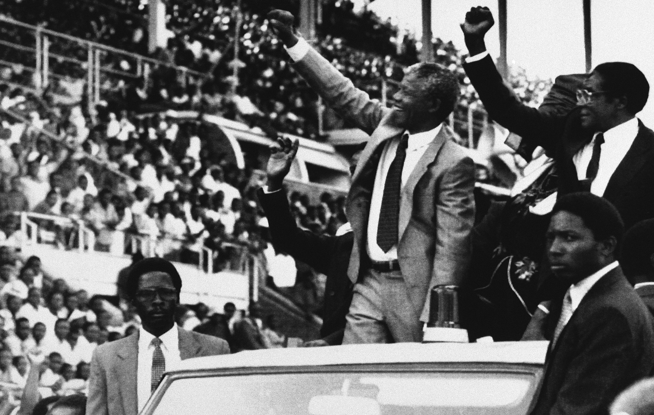 Nelson Mandela, centre, and Robert Mugabe, far right, greet the crowds at the start of the new Zimbabwe public holiday, Mandela Day, in Harare, 1990