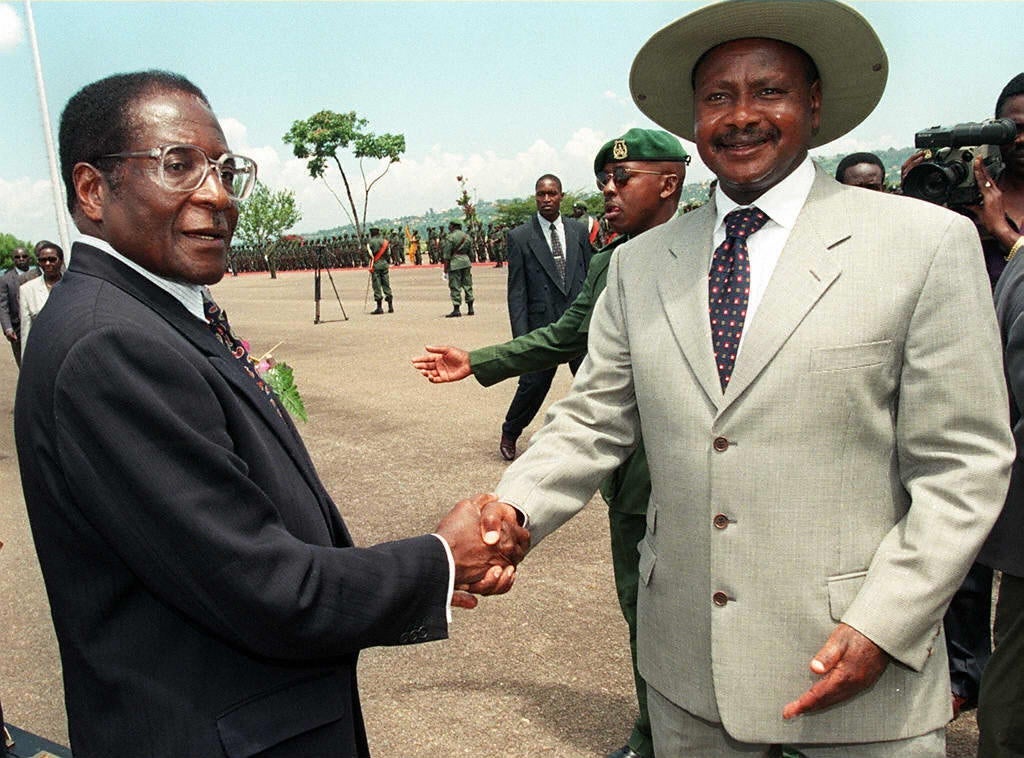 Uganda President Yoweri Museveni, right, welcomes President Robert Mugabe to Entebbe International airport in 1998