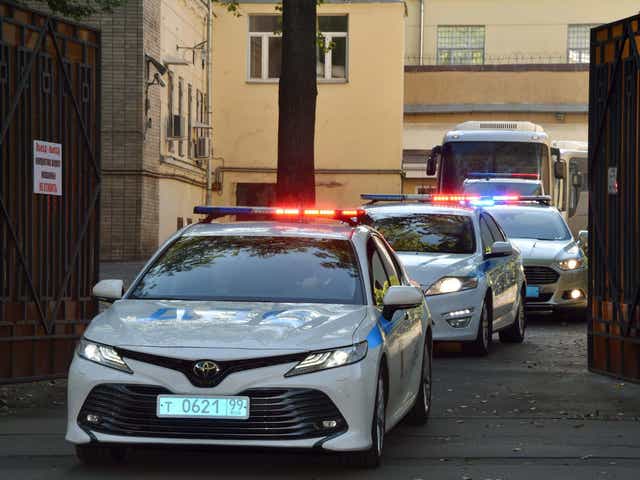A police convoy escorts two buses with tinted windows leaving the high-security prison of Lefortovo