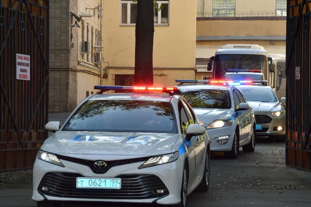 A police convoy escorts two buses with tinted windows leaving the high-security prison of Lefortovo