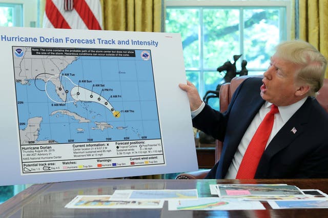 US president Donald Trump holds a chart showing the projected track of Hurricane Dorian which appears to have been altered
