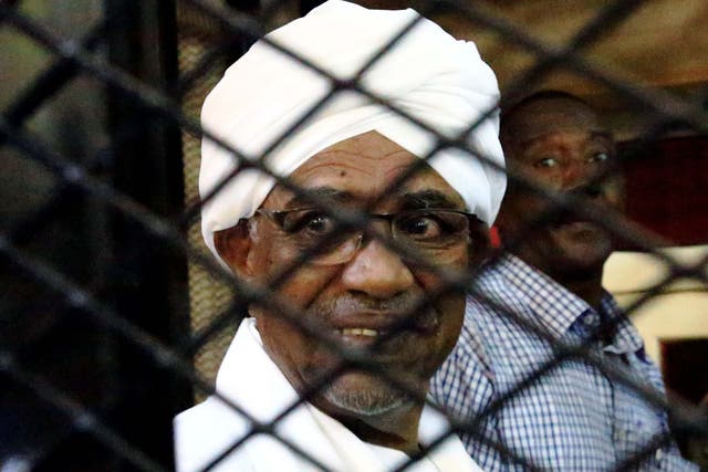Omar Hassan al-Bashir inside a cage at the courthouse where he is facing corruption charges in late August