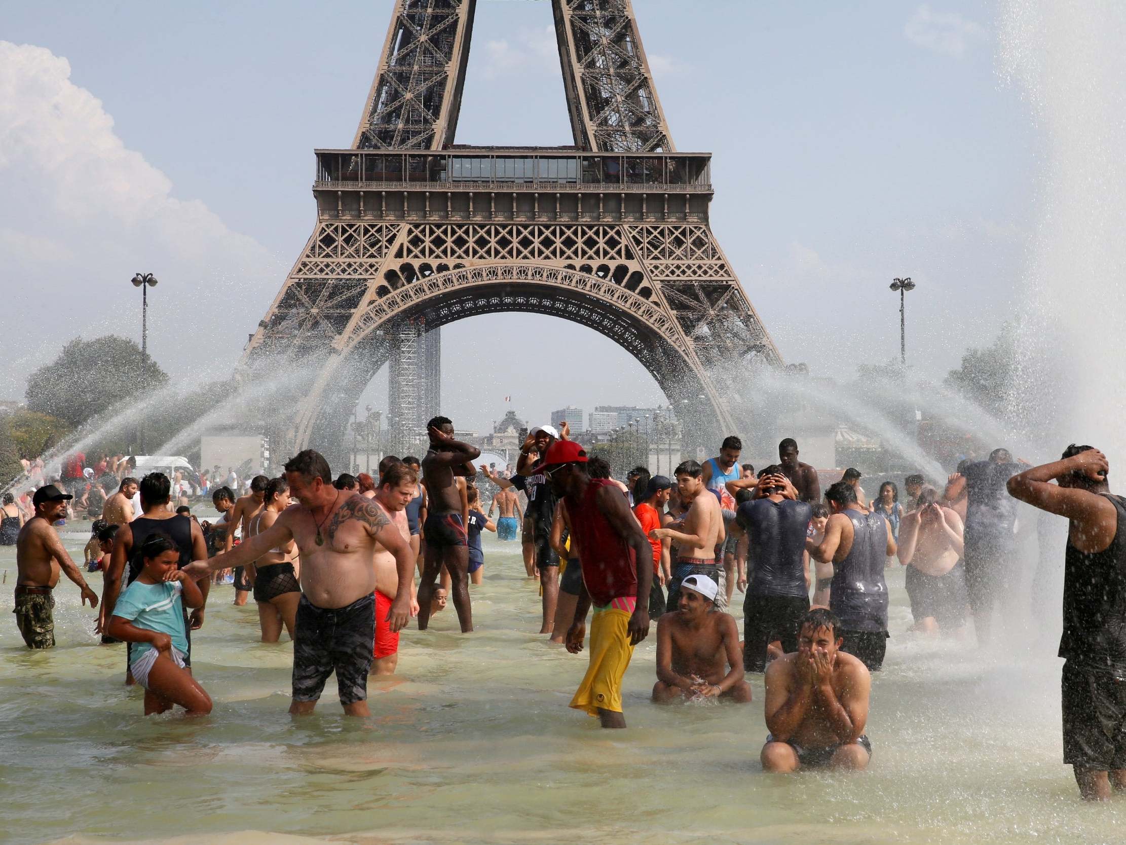 People cool off in the Trocadero fountains across from the Eiffel Tower in Paris