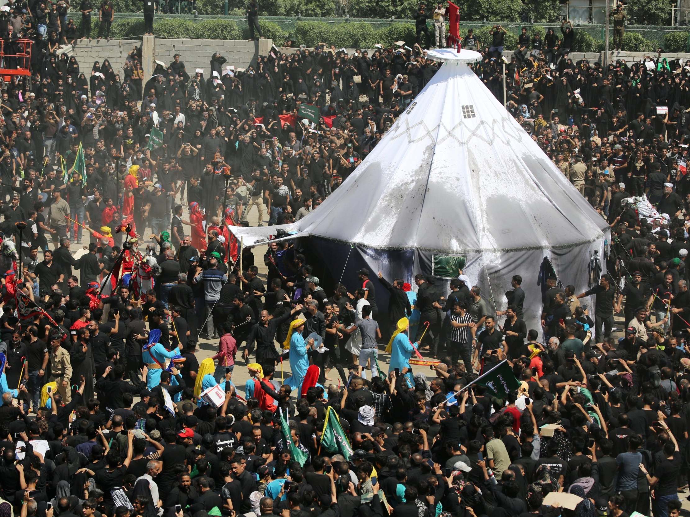 Iraqi Shia Muslims gather around a tent as they re-enact a scene as part of the Ashura ceremony in Kerbala