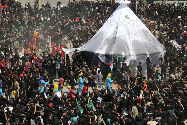 Iraqi Shia Muslims gather around a tent as they re-enact a scene as part of the Ashura ceremony in Kerbala