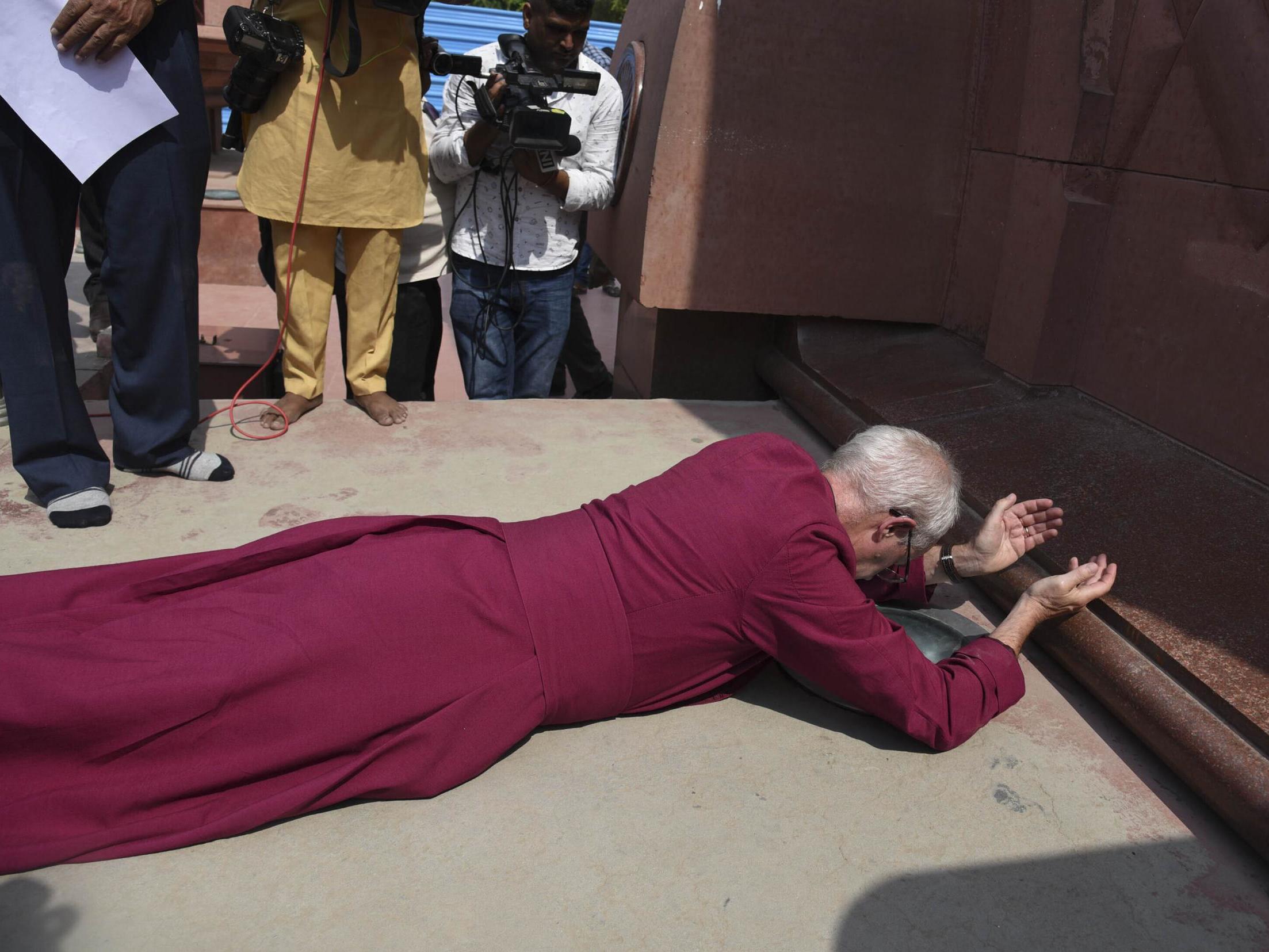 The Archbishop of Canterbury Justin Welby, prostrates as he pays respect at the Jallianwala Bagh memorial
