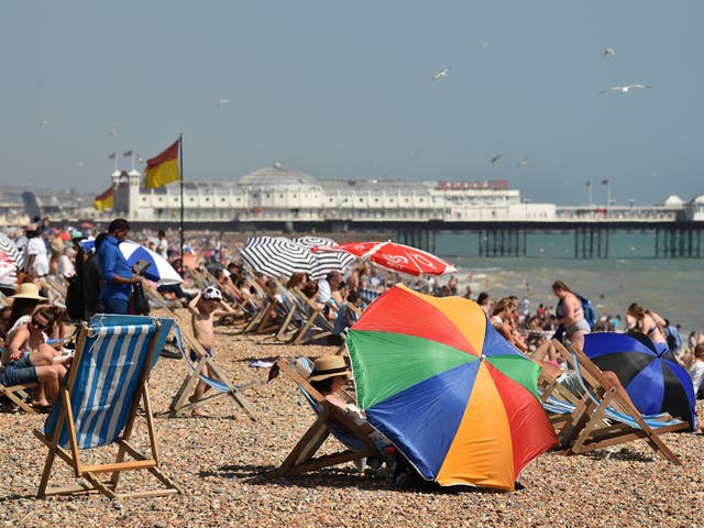 Beachgoers relax by the sea in Brighton during a heatwave in Britain.