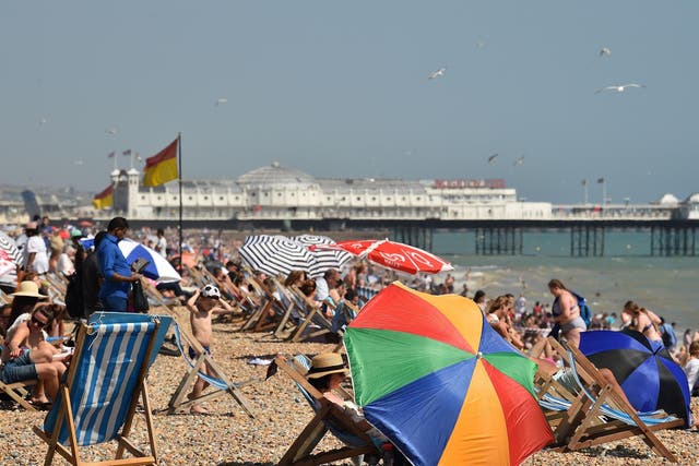 Beachgoers relax by the sea in Brighton during a heatwave in Britain.