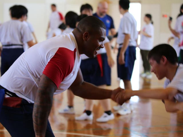 Kyle Sinckler meets one of the school kids on England's visit in Miyaaki