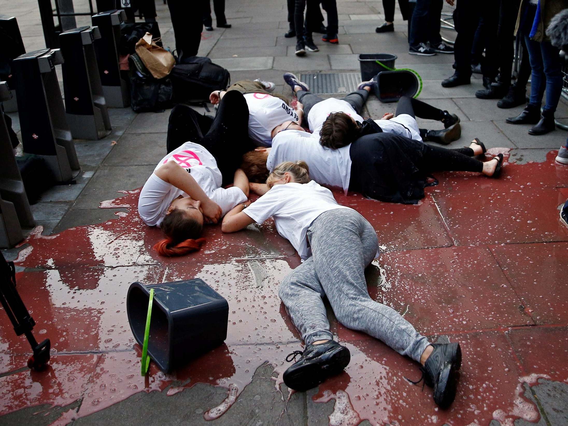 Protesters lay in red liquid outside the opening of London Fashion week