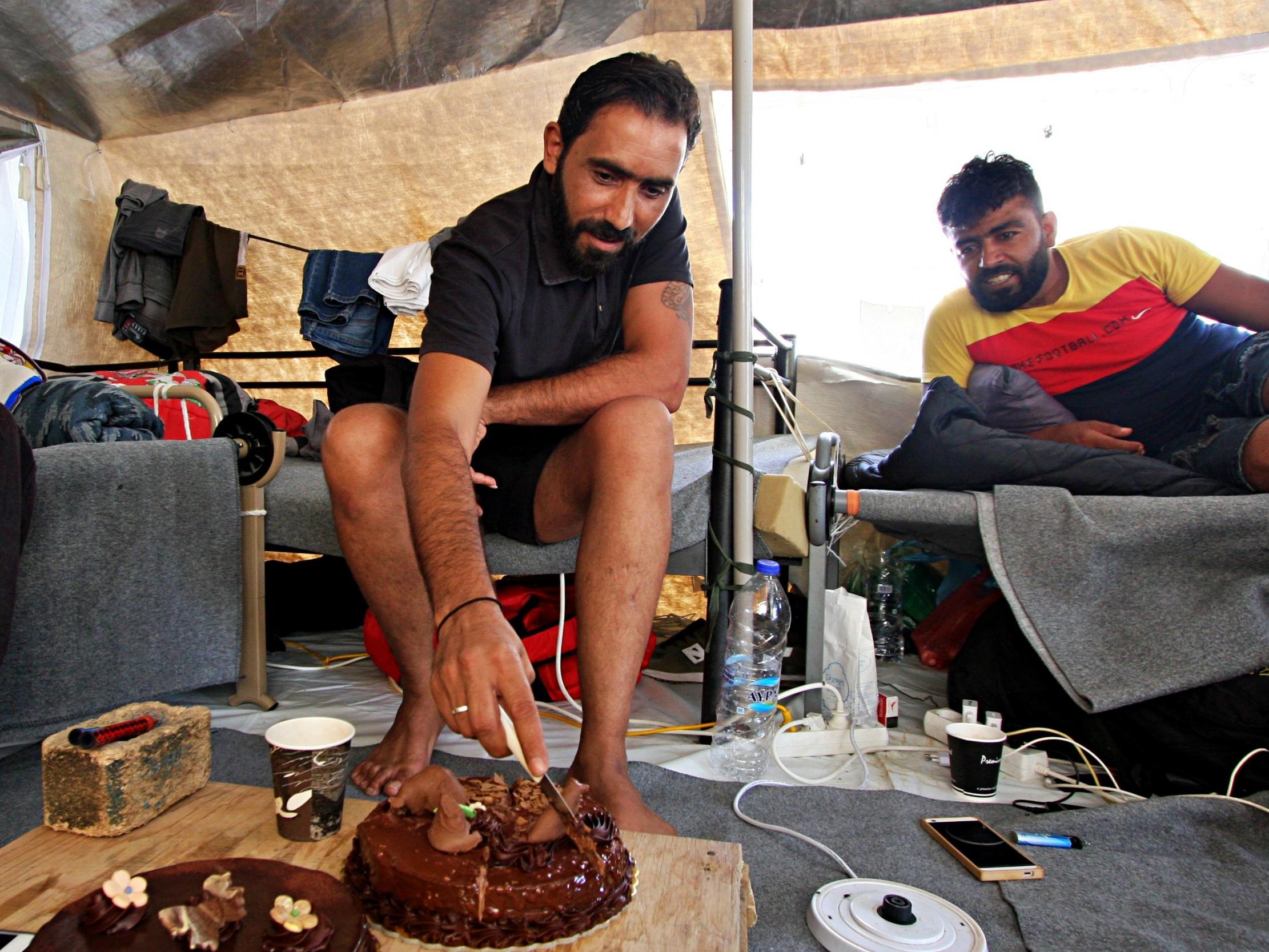 The Syrian refugee cuts his birthday cake in the tent he has called home for the last four months