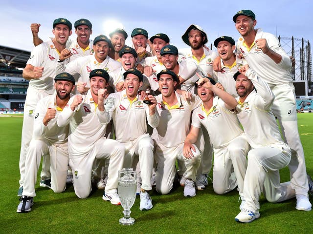 Australia's captain Tim Paine holds the Ashes Urn as the players celebrate victory