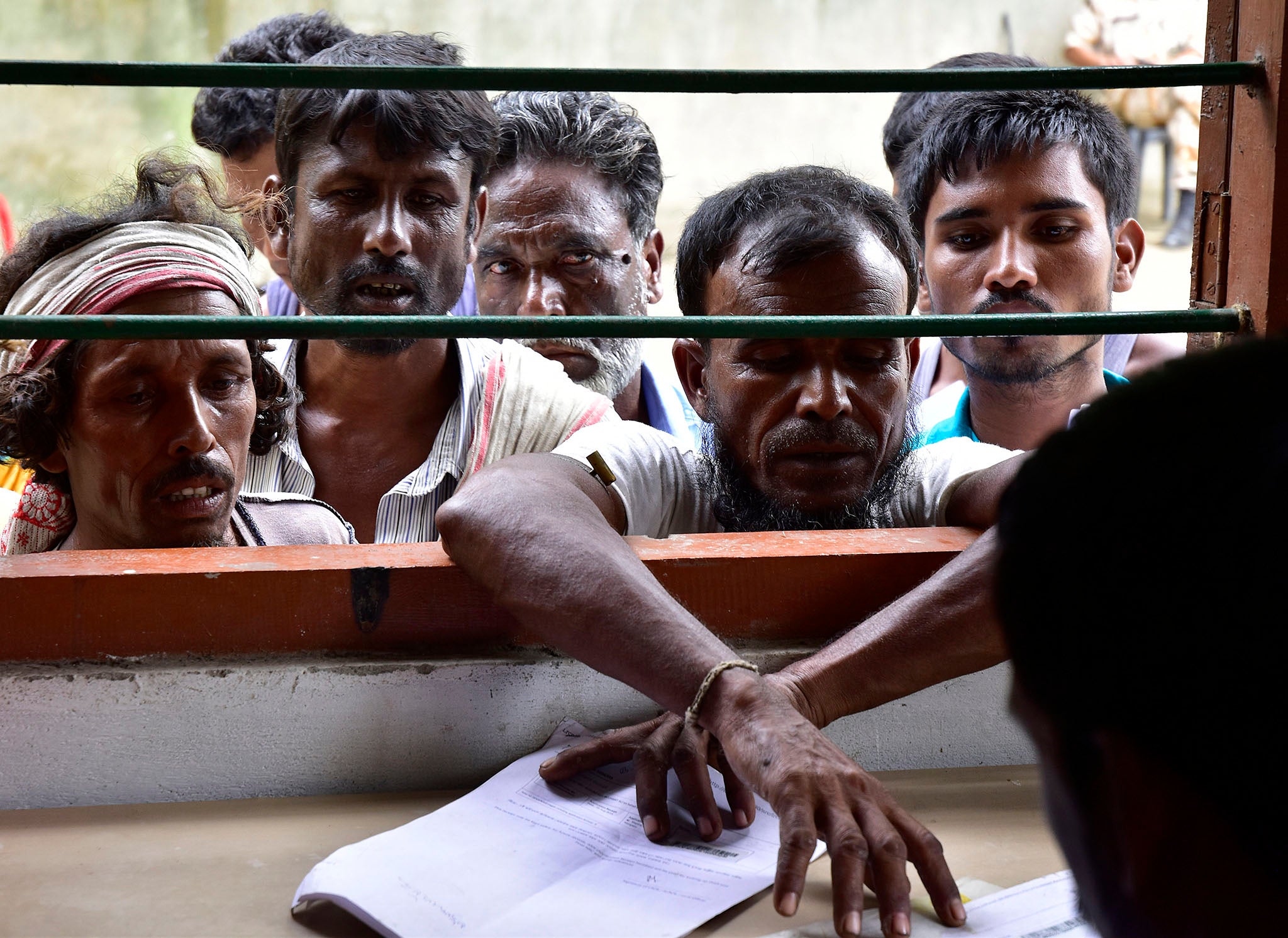 Indian villagers check their names against the final NRC list