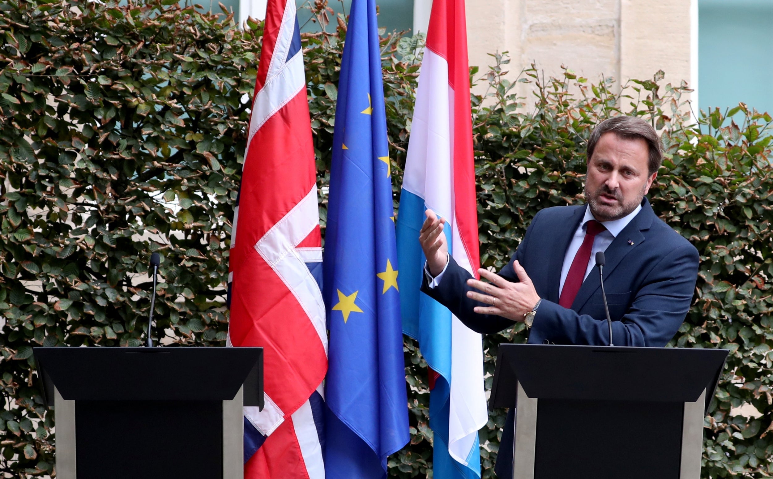 Boris Johnson 'chickens' out of own press conference amid noisy protests, leaving empty podium next to Luxembourg's PM