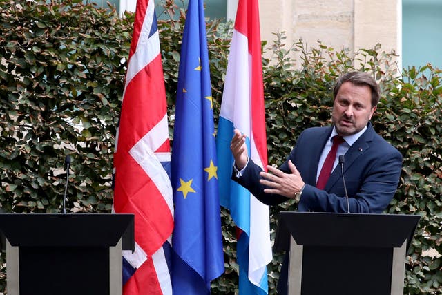 Luxembourg's Prime Minister Xavier Bettel next to an empty podium that was supposed to be for Boris Johnson