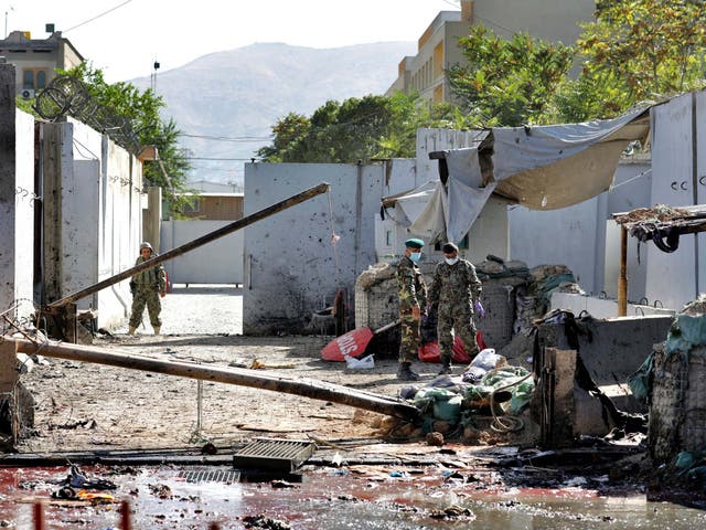 Afghan security forces work at the site of a suicide attack near the US Embassy in Kabul, Afghanistan, hours after a suicide bomb hit the president's campaign rally.