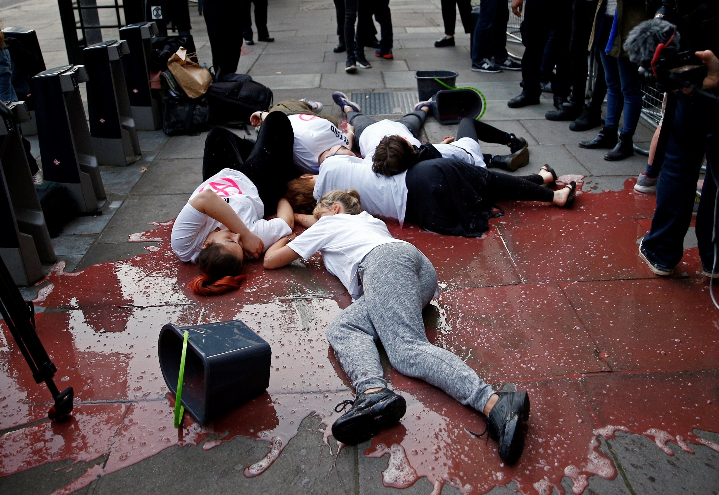 Extinction Rebellion protestors lie in fake blood outside one of the event’s venues (Reuters)
