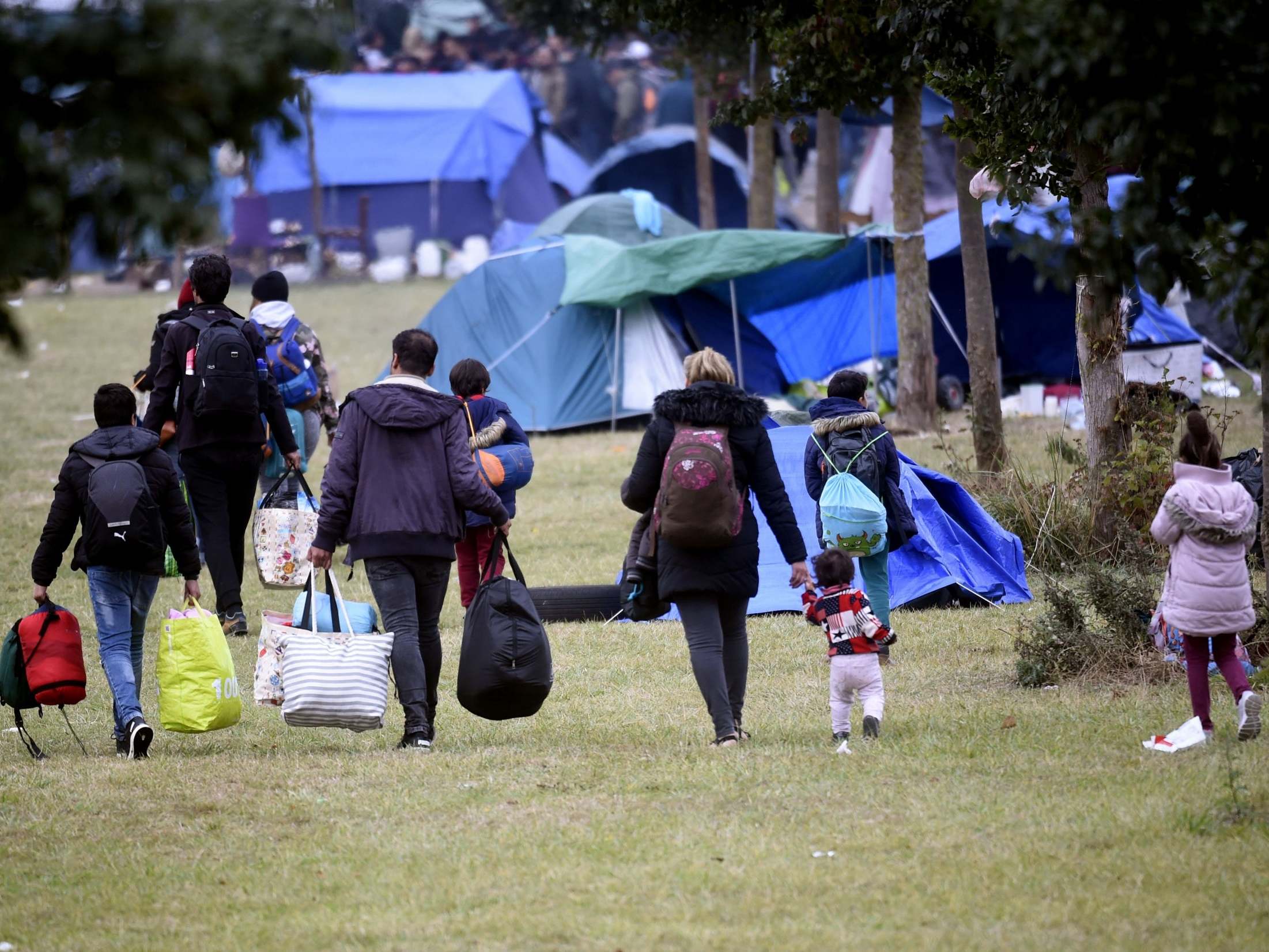 People and children leave after the eviction, by French gendarmes, of the Grande Synthe refugee camp, Dunkirk, on 17 September, 2019.