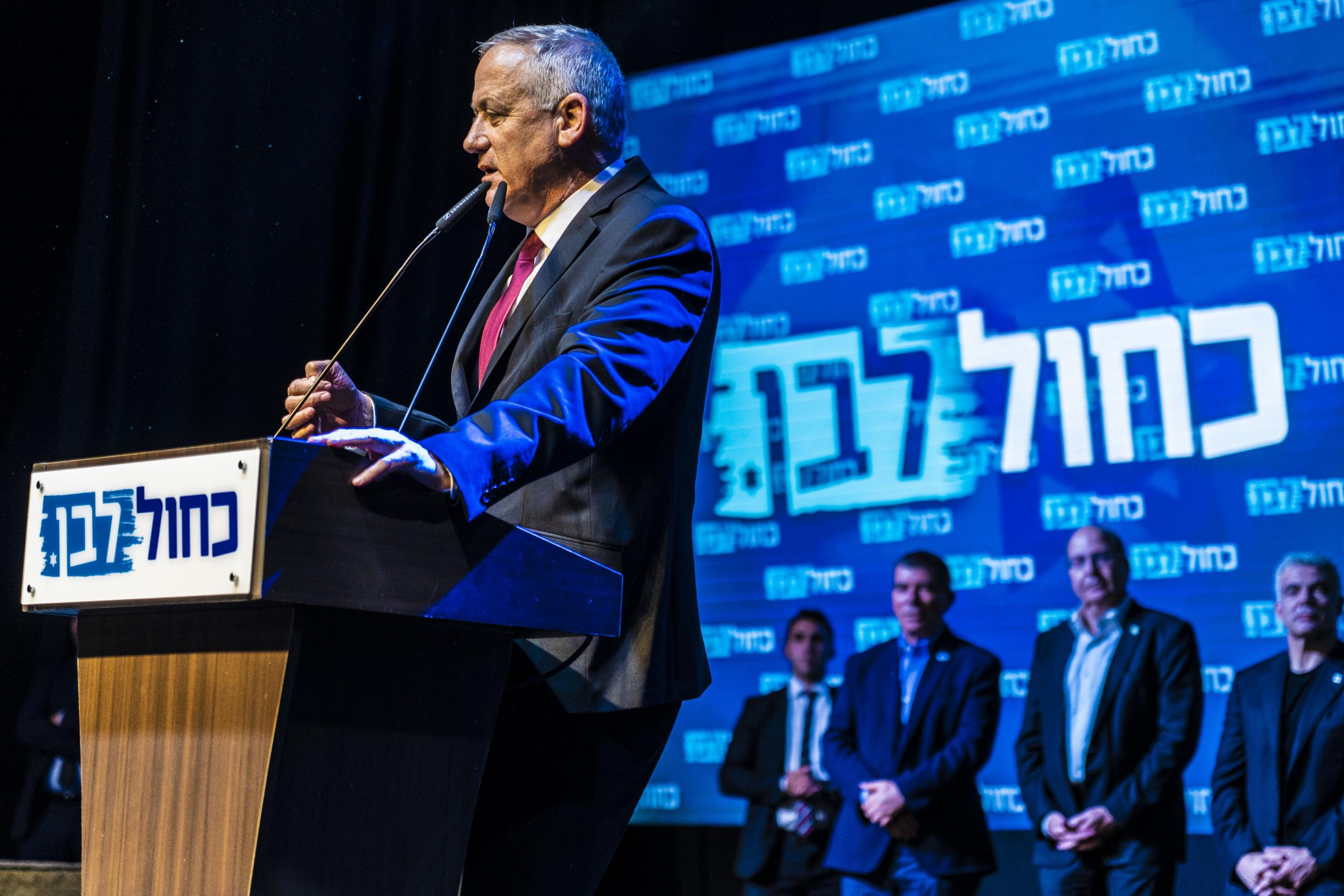 Benny Gantz addresses his supporters, with his three co-leaders behind him, after exit polls showed Mr Netanyahu had not won an outright majority