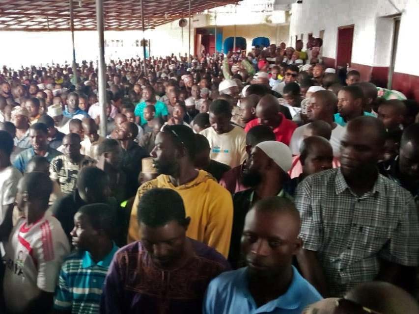 People wait for prayers to begin at a Liberian mosque after a fire swept through a school, reportedly killing dozens of children