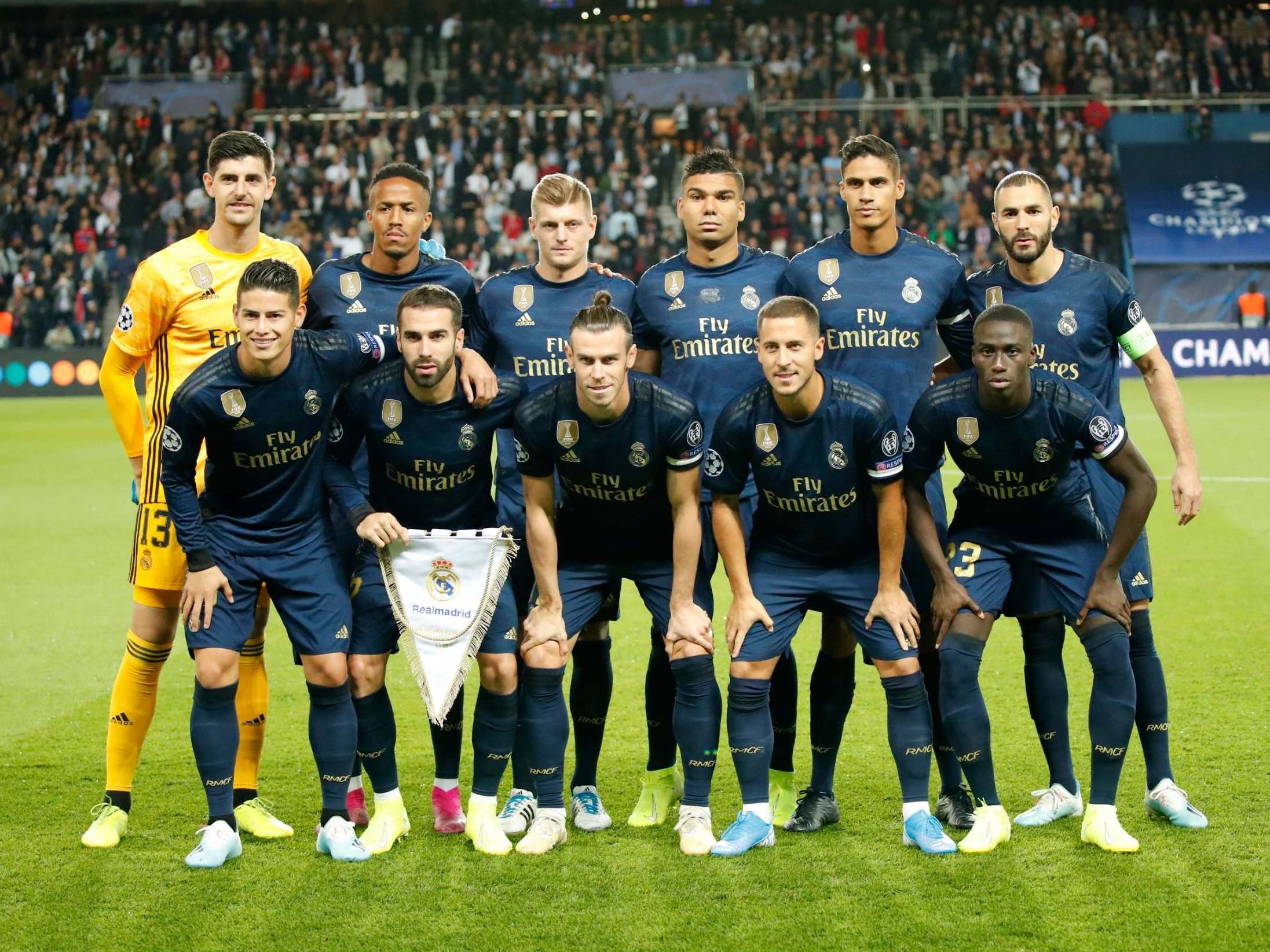 Real Madrid line up before kick-off wearing a dark blue strip