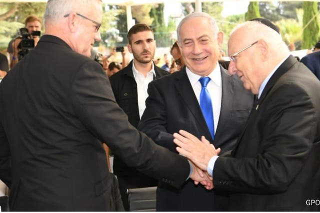 Netanyahu shakes hands with rival Gantz and president Reuven Rivlin during a ceremony marking the 3rd anniversary of Shimon Peres’s death