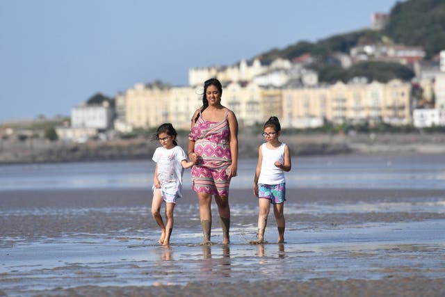 People enjoy the sunshine on the beach at Weston-super-Mare, as temperatures soar this weekend