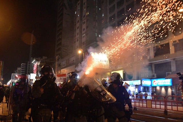 Riot police officers shoot tear gas canisters against pro-democracy protesters in Hong Kong on September 21, 2019
