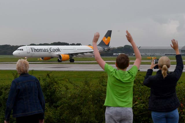 The pilot's family members wave as a Thomas Cook aircraft departs from Manchester Airport with the travel giant's future still uncertain