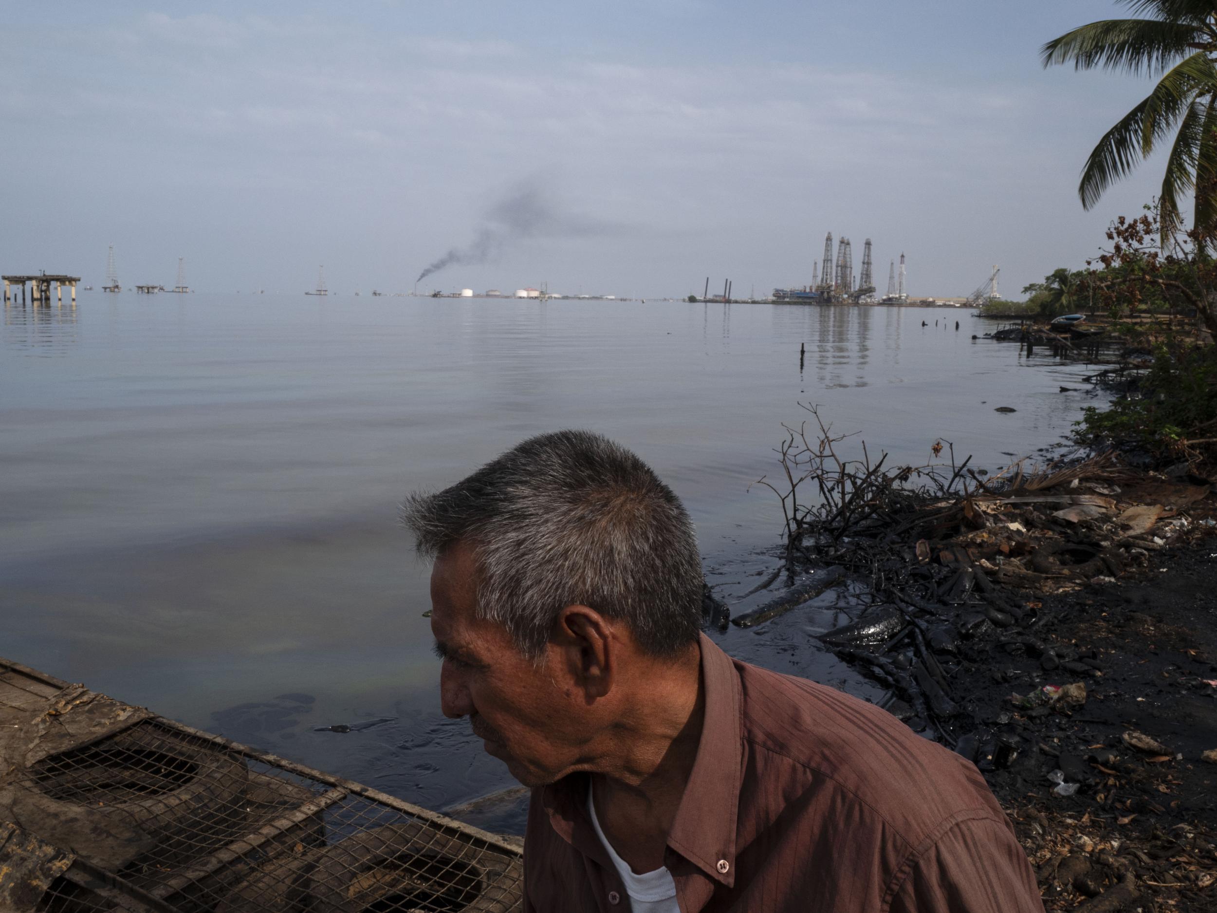 A man passes the contaminated shoreline of Lake Maracaibo