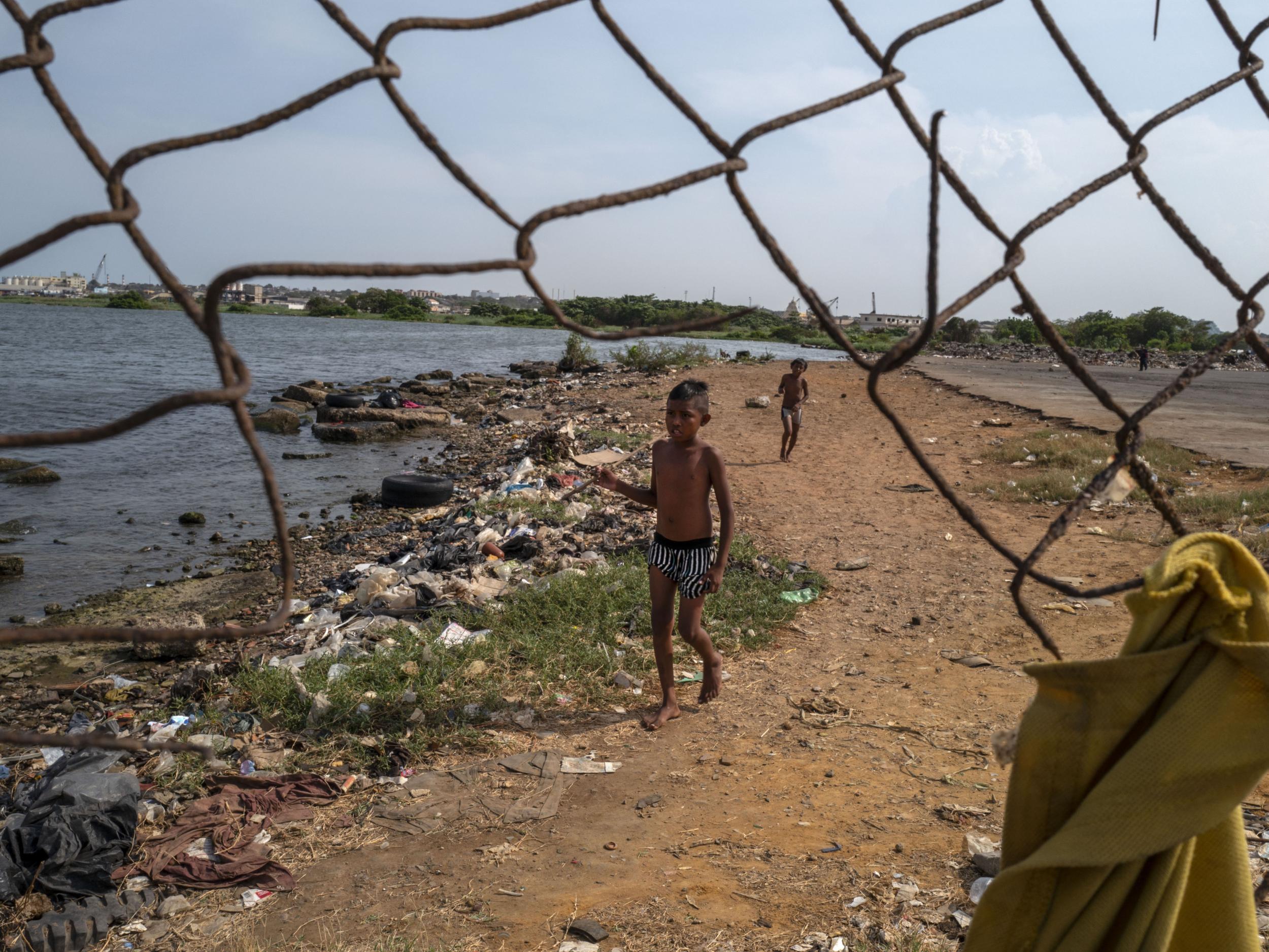 Children play on a polluted beach along Lake Maracaibo