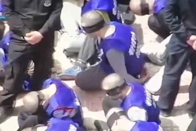 The video shows prisoners who have been blindfolded and shackled