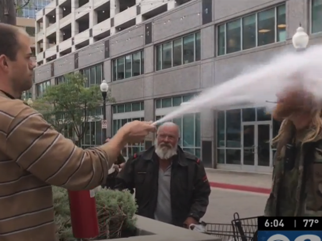 Alex Jamison sprays a fire extinguisher into the face of Jon Bird to forcibly put out his cigarette